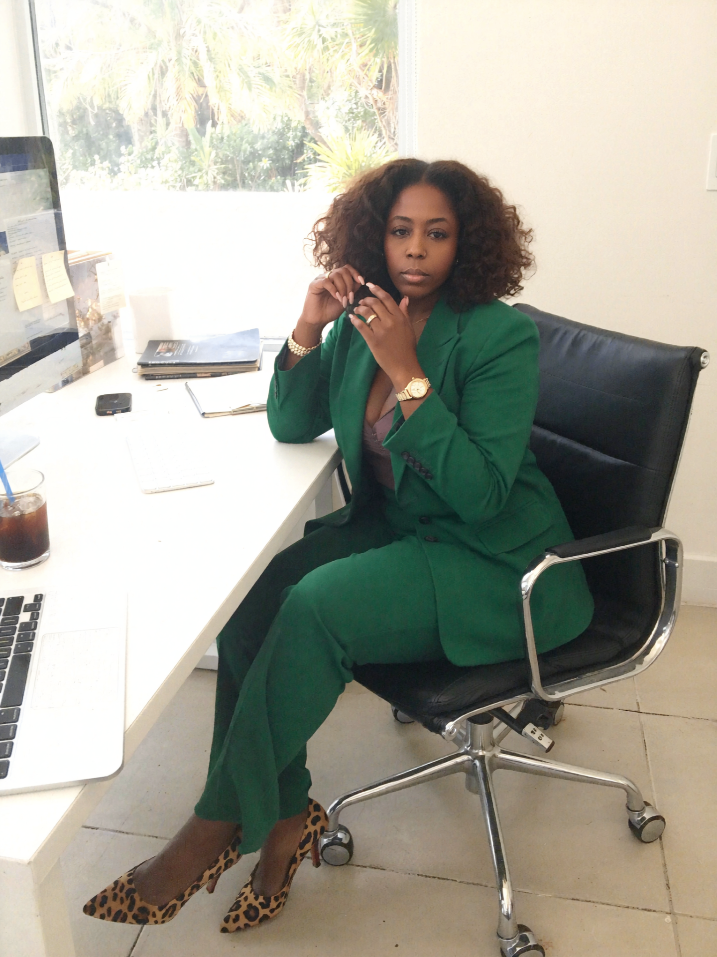 Tarean Thompson, Founder of Geaux Uptown Solutions, in green suit at her desk